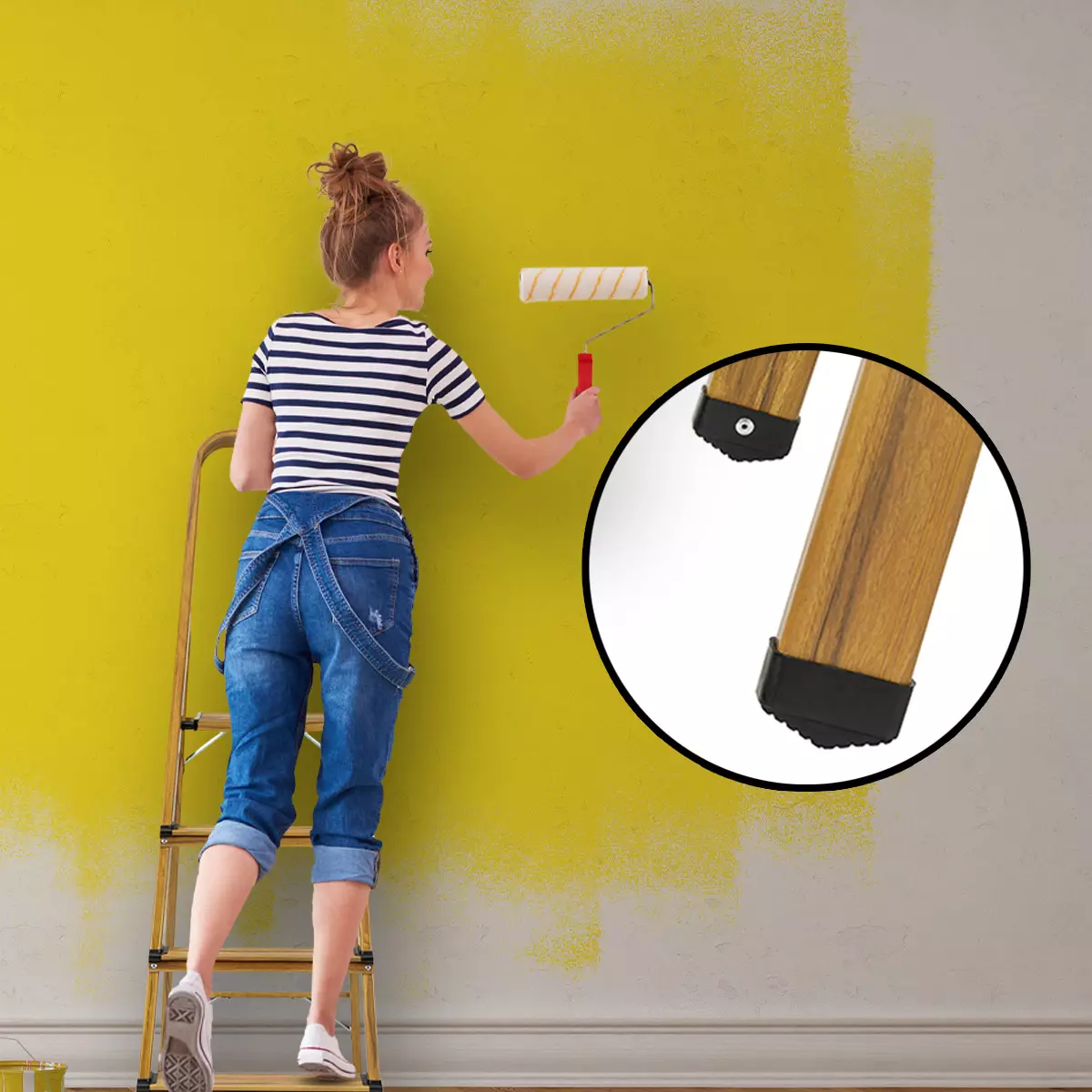 Auf Leiter stehende Frau streicht weiße Wand in Gelb